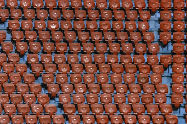 Plastic multi-colored seats for spectators in the amphitheater of the football stadium. Conceptual background of empty seats in the stadium