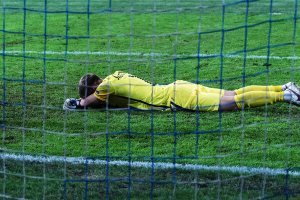 ODESSA, UKRAINE - September 15, 2016: Zarya FC goalkeeper Andrei Lunin reacts emotionally to the missed goal. The goalkeeper lies on the football field after the goal scored in the goal