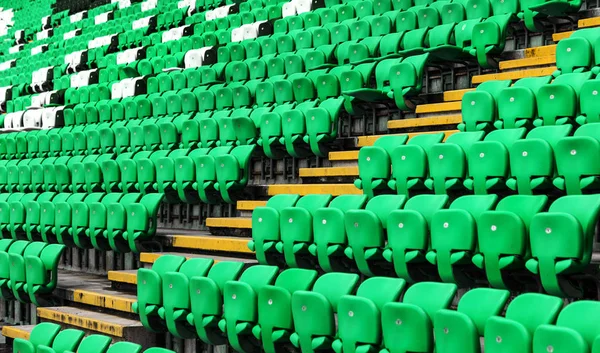 Empty old plastic chairs in the stands of the stadium. Many empty seats for spectators in the stands. Empty plastic chairs, seats for football fans. Tribune, game without spectators