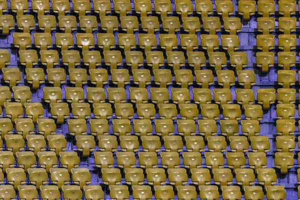 Plastic multi-colored seats for spectators in the amphitheater of the football stadium. Conceptual background of empty seats in the stadium