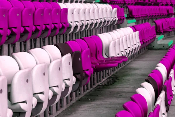 Empty old plastic chairs in the stands of the stadium. Many empty seats for spectators in the stands. Empty plastic chairs, seats for football fans. Tribune, game without spectators