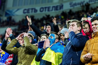 Odessa, Ukrayna - 24 Mart 2016: Futbol taraftarları ve seyirci stadyum standları duygusal onların Ukrayna ve Kıbrıs Milli takım maç sırasında destek ekibi. Duygular, el fenerleri, duman, çığlıkları