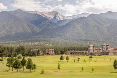 Razlık, Bulgaristan - 29 Temmuz 2016: Pirin Dağı sayısı Todorka ve Vihren en üstündeki. Güzel görünüm yeşil yaz golf sahası. Resort Razlık, Bulgaristan