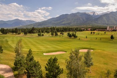 Razlık, Bulgaristan - 29 Temmuz 2016: Pirin Dağı sayısı Todorka ve Vihren en üstündeki. Güzel görünüm yeşil yaz golf sahası. Resort Razlık, Bulgaristan