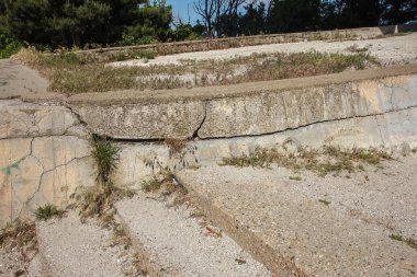 Çatlaklar. Arka plan yüzeyi ile yaratıcı çatlaklar. Yaratıcı tasarım düzen için arka plan olarak Web çatlaklar. Çimento tabakasının taş yüzeyi derin çatlaklar oluşan bir ağ ile. Endişeli görünüm