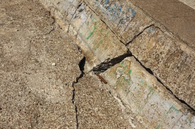 Çatlaklar. Arka plan yüzeyi ile yaratıcı çatlaklar. Yaratıcı tasarım düzen için arka plan olarak Web çatlaklar. Çimento tabakasının taş yüzeyi derin çatlaklar oluşan bir ağ ile. Endişeli görünüm