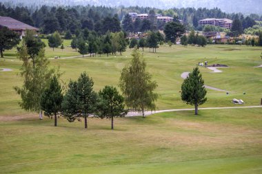 Razlık, Bulgaristan - 29 Temmuz 2016: Pirin Dağı sayısı Todorka ve Vihren en üstündeki. Güzel görünüm yeşil yaz golf sahası. Resort Razlık, Bulgaristan