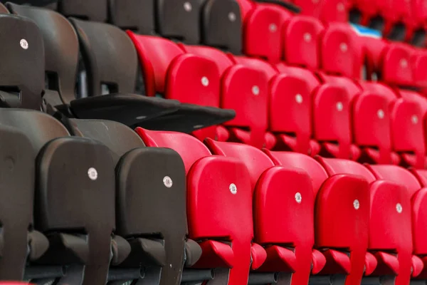 Empty old plastic chairs in the stands of the stadium. Many empty seats for spectators in the stands. Empty plastic chairs, seats for football fans. Tribune, game without spectators