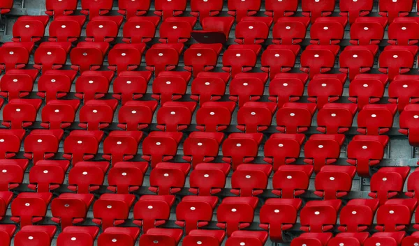 Plastic multi-colored seats for spectators in the amphitheater of the football stadium. Conceptual background of empty seats in the stadium