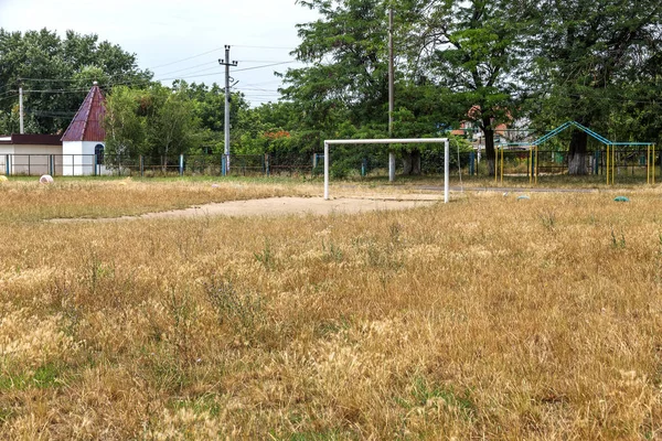 废弃的农村体育场 没有割草草坪场 被践踏的秃顶禁区的一个农村废弃足球场有一个大门 — 图库照片