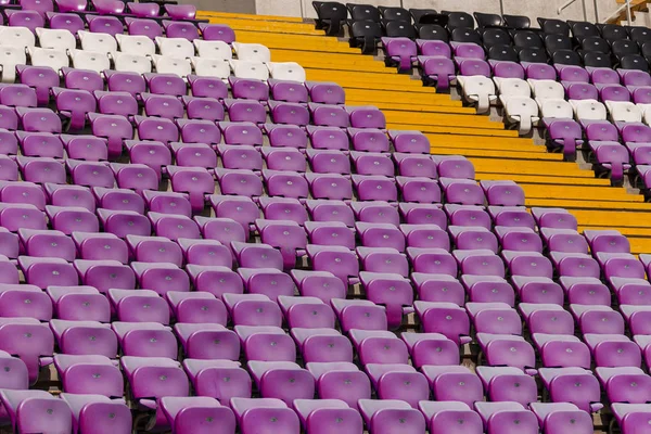 Empty old plastic chairs in the stands of the stadium. Many empty seats for spectators in the stands. Empty plastic chairs, seats for football fans. Tribune, game without spectators