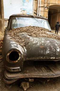 Bir gereksiz eski paslı makine zavallı ilçe şehir avlusunda terk edilmiş. Eski, terk edilmiş bir araba farlar olmadan. Ayrıştırmak ve bahçede pas için terk paslı binek otomobil
