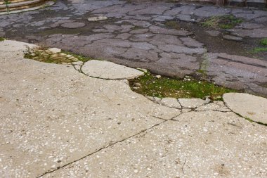 Kötü yol. Kötü asfalt. Asfalt güzel parlak derin çatlaklar Web. Yolda çatlaklar moss ile büyümüş. Yol onarım. Terk edilmesi, harabe, enkaz, kriz yaratıcı arka plan. Yıkık asfalt