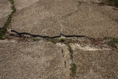 Çatlaklar. Arka plan yüzeyi ile yaratıcı çatlaklar. Yaratıcı tasarım düzen için arka plan olarak Web çatlaklar. Çimento tabakasının taş yüzeyi derin çatlaklar oluşan bir ağ ile. Endişeli görünüm