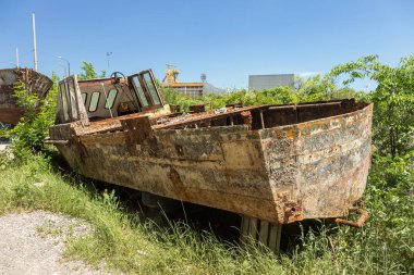 Eski terk edilmiş kırık tekne kıyıda ölür. Küçük bir gemi parçası. Paslı donanımları, midye teknenin altındaki bir koloni. Eski hasarlı tekne