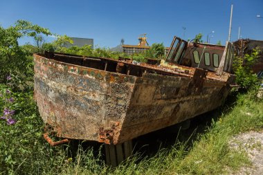 Eski terk edilmiş kırık tekne kıyıda ölür. Küçük bir gemi parçası. Paslı donanımları, midye teknenin altındaki bir koloni. Eski hasarlı tekne