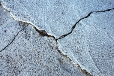 Çatlaklar. Arka plan yüzeyi ile yaratıcı çatlaklar. Yaratıcı tasarım düzen için arka plan olarak Web çatlaklar. Çimento tabakasının taş yüzeyi derin çatlaklar oluşan bir ağ ile. Endişeli görünüm