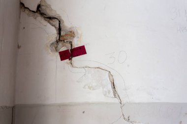 Duvarında çatlaklar. Eski duvar sıva, delik çatlaklar. Çatlamak yayılma denetimi sekme denetim işaretleri. Alçı duvar büyük çatlak