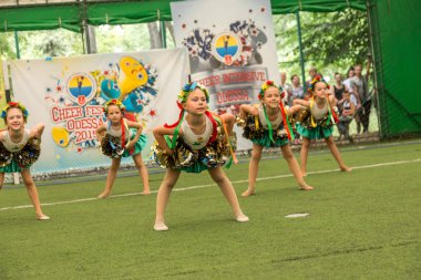 Odessa, Ukrayna -30 Mayıs 2015: Amigo Şampiyonası Ukrayna çocuklar arasında. Çocuk bir güzel parlak dans formla Sportin becerilerini göster. Birçok seyirci ve sporcular. Büyüleyici otantik çocuk