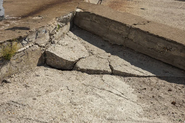 Çatlaklar. Arka plan yüzeyi ile yaratıcı çatlaklar. Yaratıcı tasarım düzen için arka plan olarak Web çatlaklar. Çimento tabakasının taş yüzeyi derin çatlaklar oluşan bir ağ ile. Endişeli görünüm