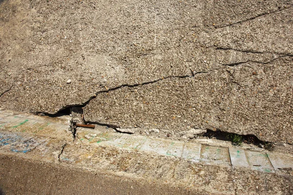Çatlaklar. Arka plan yüzeyi ile yaratıcı çatlaklar. Yaratıcı tasarım düzen için arka plan olarak Web çatlaklar. Çimento tabakasının taş yüzeyi derin çatlaklar oluşan bir ağ ile. Endişeli görünüm
