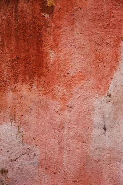 old concrete plastered wall is spoiled by abstract strokes and stains of paint. Concrete, weathered, worn out wall, damaged paint. artistic texture of wall. Painted bad scratched surface in crack