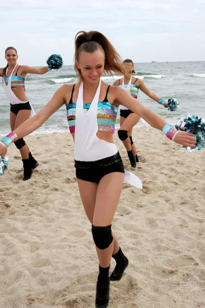 オデッサ ウクライナ 2010 女性のサポート グループのスポーツ チーム 砂浜で黒海の明るいダイナミックなパフォーマンス Aktion のチアリーダー スポーツウェアの明るい美しい少女 — ストック写真