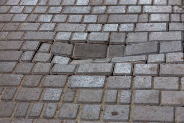 Çukurlar, kışın donma-çözülme çevrimleri neden olan bozuk asfalt yol. Kötü yol. Kaldırımlar kaldırımlar kaldırımda kırık. kaldırım döşeme ile kusurları ile tabaka ve perspektif içinde gelen çatlaklar