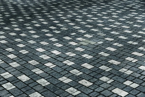 beautiful background laid paving slabs on pedestrian path. Monotonous pattern of multicolored glazed paving slabs. Photo site with paving slabs with small defects and cracks coming out in perspective