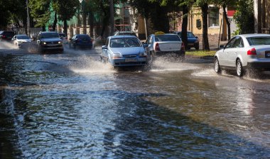 Odessa, Ukrayna -3 Temmuz 2018: yağmur fırtına tarafından neden olduğu sel sırasında su dolu bir yolda araba sürmek. Arabalar sokaklarda sel su üzerinde yüzer. Sıçramak üstünde belgili tanımlık makine. Büyük bir su birikintisi olan sular altında şehir yol