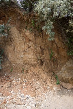 Çevreye zararlı bir bölgede dağ heyelan. Yeryüzündeki büyük çatlaklar, toprak yolu kapatan büyük katmanların inişi. Dağ yamacının yamacında baraj tehlikesi