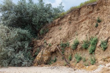 Çevreye zararlı bir bölgede dağ heyelan. Yeryüzündeki büyük çatlaklar, toprak yolu kapatan büyük katmanların inişi. Dağ yamacının yamacında baraj tehlikesi