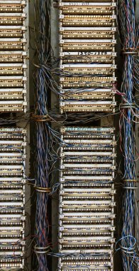 Şehir sokak eski analog telefon geçiş panosunda. Kırık, yağmalanmış terk edilmiş kırık eski telefon santral sabit hat kablolu. Kablo kanalı, telefon asılı kabine teller