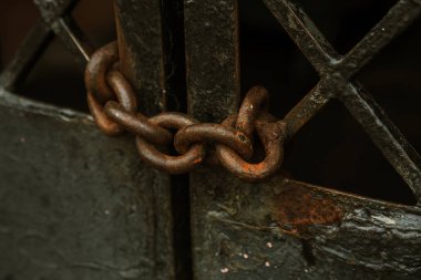 Eski paslı kalın demir zinciri demir kapıları korur. Zincir halinde eski demir ağ geçidi yetkisiz erişime karşı korur. Paslı demir zinciri