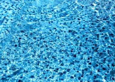 Parlak mavi su arka planında, beyaz ve mavi Venedik mozaik fayanslarıyla kaplı modern moda yüzme havuzu var. 