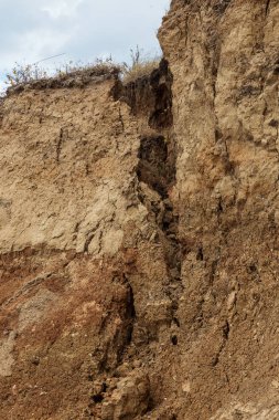 Çevreye zararlı bir bölgede dağ heyelan. Yeryüzündeki büyük çatlaklar, toprak yolu kapatan büyük katmanların inişi. Dağ yamacının yamacında baraj tehlikesi