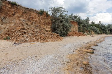 Çevreye zararlı bir bölgede dağ heyelan. Yeryüzündeki büyük çatlaklar, toprak yolu kapatan büyük katmanların inişi. Dağ yamacının yamacında baraj tehlikesi
