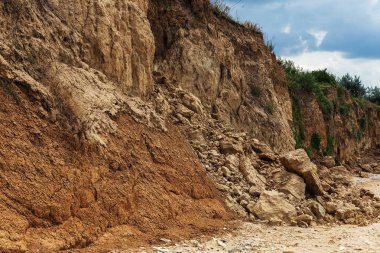 Çevreye zararlı bir bölgede dağ heyelan. Yeryüzündeki büyük çatlaklar, toprak yolu kapatan büyük katmanların inişi. Dağ yamacının yamacında baraj tehlikesi