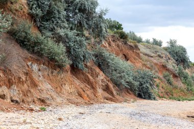 Çevreye zararlı bir bölgede dağ heyelan. Yeryüzündeki büyük çatlaklar, toprak yolu kapatan büyük katmanların inişi. Dağ yamacının yamacında baraj tehlikesi