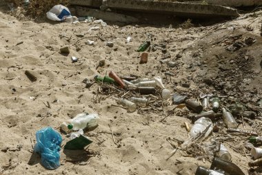 Büyük şehrin plajda dökülen çöp. Boş kirli plastik şişeler kullanılır. Kirli deniz kumlu kıyı Karadeniz. Çevre kirliliği. Ekolojik sorun. Çöplüğü çit HalkPlajı yakınındaki
