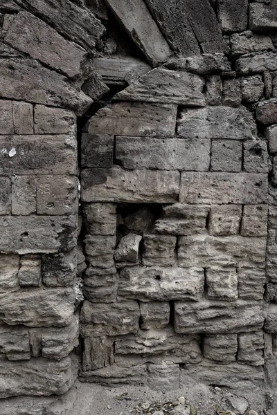 An old destroyed wall with large large cracks. Background of crack on an old wall as background for creative design. Destroyed cracked wall of building after earthquake and hurricane