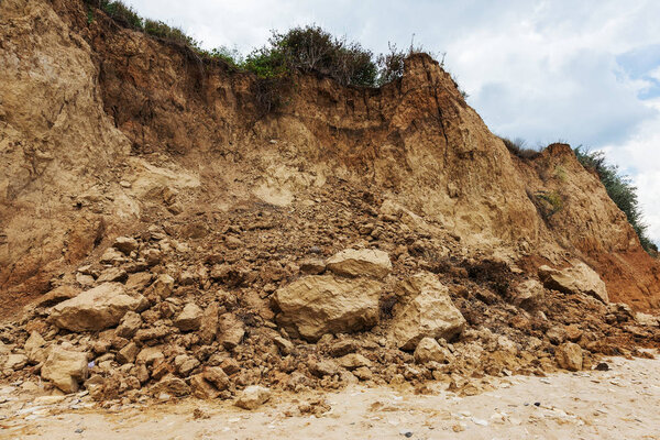 Mountain landslide in an environmentally hazardous area. Large cracks in earth, descent of large layers of earth blocking road. Mortal danger of dam at foot of landslide slopes of mountain