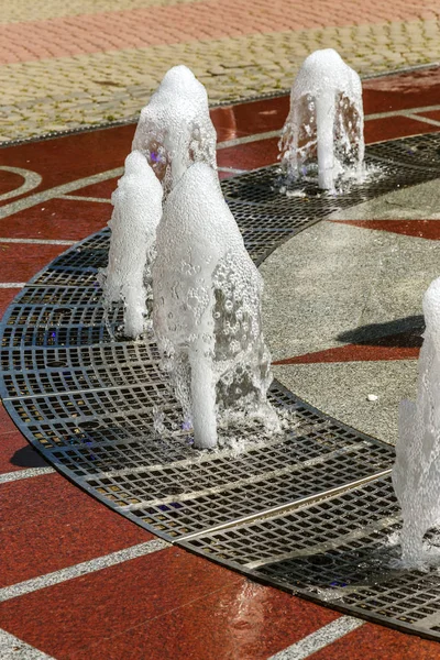 Flow of water of city fountain. Water splash, abstract image. Foam in jet of water. Flow of water fountain. Fragment of recreation zone of the city park of the southern city of Abrau-Durso, Russia