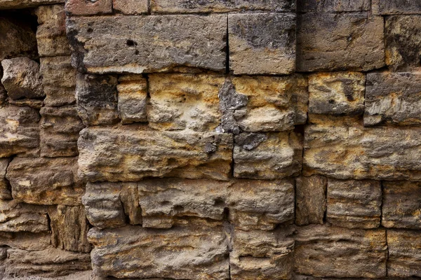 An old destroyed wall with large large cracks. Background of crack on an old wall as background for creative design. Destroyed cracked wall of building after earthquake and hurricane