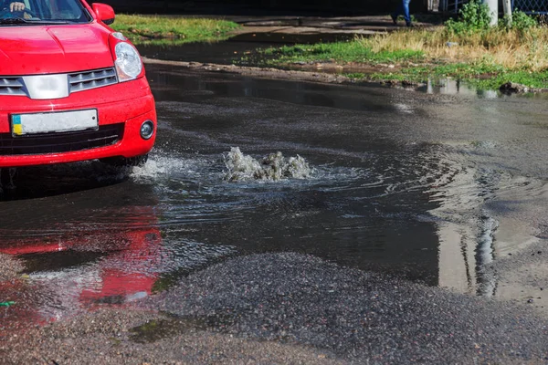 Water flows out of road sewage hatch. Drainage fountain of sewage. Accident of sewage system. Dirty sewage water flows fountain on road. From hatch fountain flows water