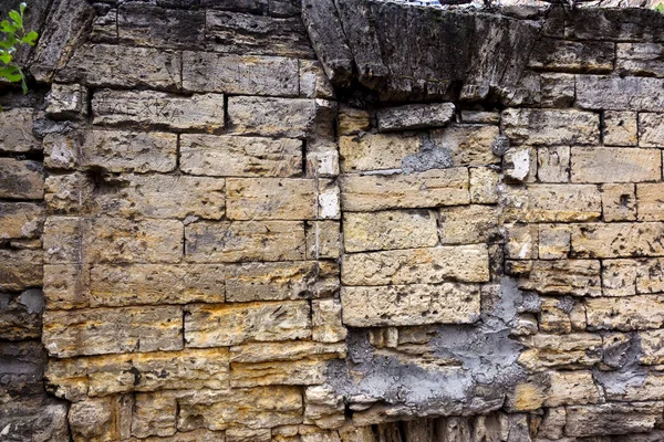 An old destroyed wall with large large cracks. Background of crack on an old wall as background for creative design. Destroyed cracked wall of building after earthquake and hurricane