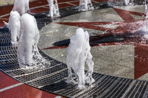 Flow of water of city fountain. Water splash, abstract image. Foam in jet of water. Flow of water fountain. Fragment of recreation zone of the city park of the southern city of Abrau-Durso, Russia