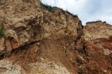 Çevreye zararlı bir bölgede dağ heyelan. Yeryüzündeki büyük çatlaklar, toprak yolu kapatan büyük katmanların inişi. Dağ yamacının yamacında baraj tehlikesi