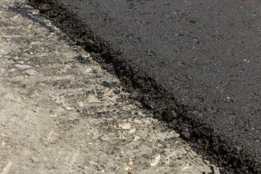 Bir otomobil şehir yol inşaatı. Yeni asfalt yolda. Yeni asfalt döşeme zaman taze sıvı, sıcak asfalt güzel akar. Soyut bitüm asfalt üzerinde graffiti tarzında akar