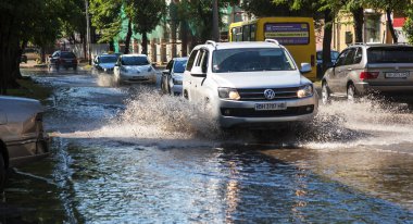 Odessa, Ukrayna -3 Temmuz 2018: yağmur fırtına tarafından neden olduğu sel sırasında su dolu bir yolda araba sürmek. Arabalar sokaklarda sel su üzerinde yüzer. Sıçramak üstünde belgili tanımlık makine. Büyük bir su birikintisi olan sular altında şehir yol